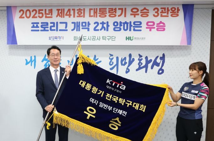 정명근 화성특례시장이 화성도시공사 탁구단으로부터 우승기를 전달받고 있다