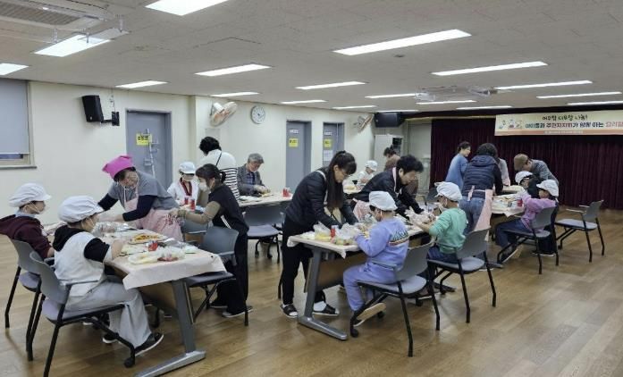 도봉1동 주민자치회 복지분과 회원들과 지역 아동들이 함께 김밥을 만들고 있다.