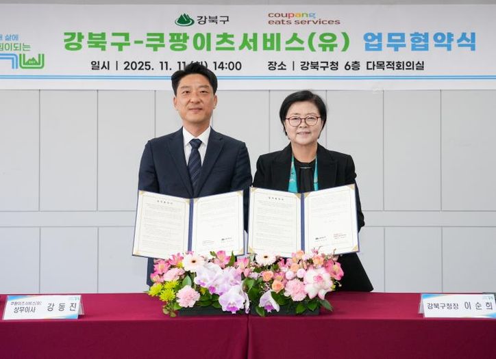 이순희 강북구청장(오른쪽)과 강동진 쿠팡이츠서비스 상무이사가 11일 강북구청 다목적회의실에서 업무협약을 체결한 뒤 협약서를 들어 보이고 있다.