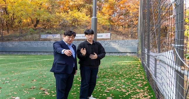 박철우 의원(왼쪽)이 삼각산 족구장 인조잔디 포장 및 배수시설 정비 현장을 점검하며 주민 이용 편의 향상 방안을 논의하고 있다.