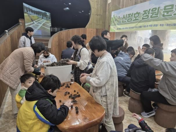 장애인 단체에서 솔방울을 만지며 체험을 하는 모습