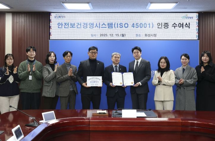정구원 화성특례시 제1부시장 및 안상현 ISO 45001 선임 심사원 등 관계자가 안전보건경영시스템 인증식에서 기념 촬영을 하고 있다