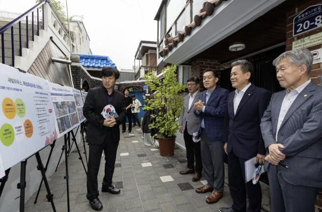 수원시와 한국보훈복지의료공단이 수원지역 독립유공자 후손의 집수리를 지원한 새빛하우스 앞에서 관계자들이 사업 설명을 듣고 있다.