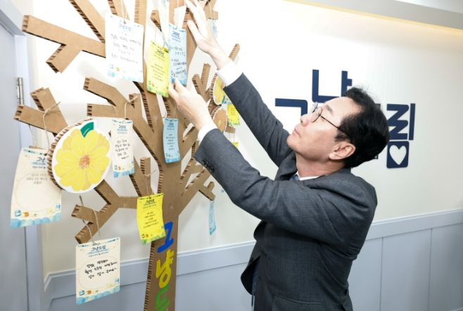 정명근 화성특례시장이 그냥드림 내부 '희망나무'에 작성한 쪽지를 달고 있다.