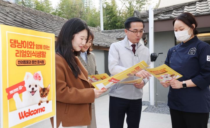 박희조 동구청장과 직원들이 반려견 동반음식점에서 설명을 듣고 있다