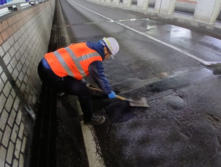 천안시 도로보수원들이 겨울철 폭설과 염화칼슘 영향으로 훼손된 도로 포트홀 구간에 아스콘을 충진하며 긴급 복구 작업을 진행하고 있다