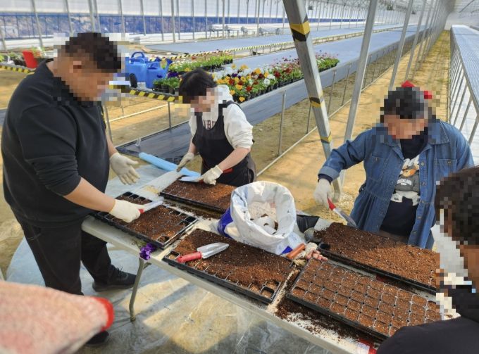 중증장애인들이 작업장에서 작업하는 사진